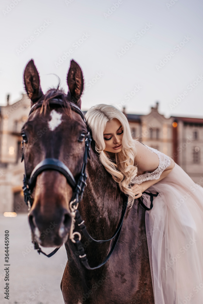 Obraz premium Beautiful woman with horse near castle