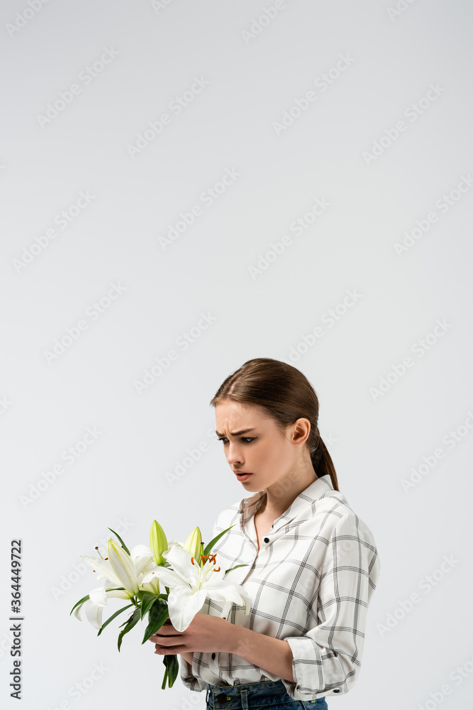 confused attractive girl posing like puppet with flowers isolated on grey confused attractive girl posing like puppet with flowers isolated on grey