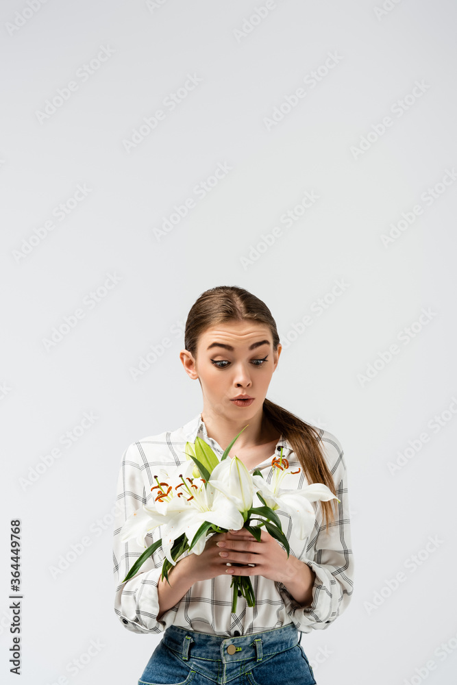 shocked attractive girl posing like puppet with flowers isolated on grey shocked attractive girl posing like puppet with flowers isolated on grey