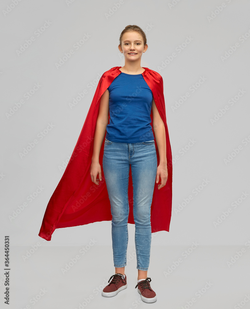 Φωτογραφία power and people concept - smiling teenage girl in red superhero cape over grey