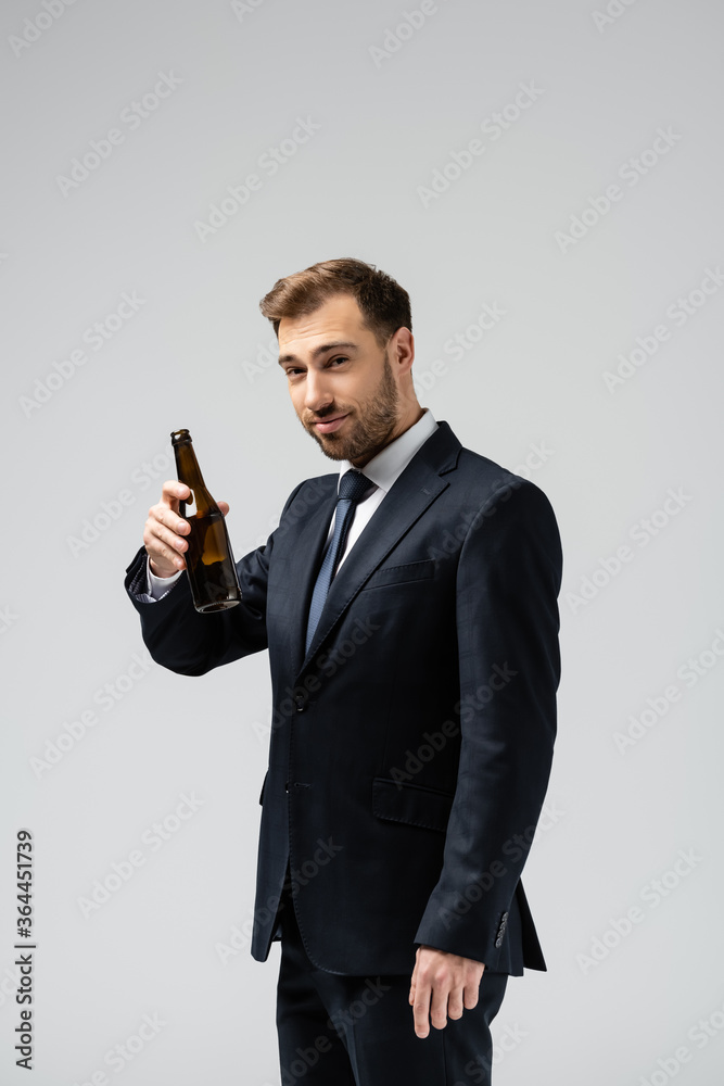 handsome businessman in suit with beer isolated on grey handsome businessman in suit with beer isolated on grey
