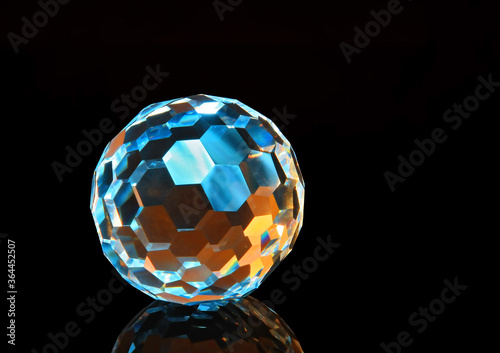 Faceted glass sphere on a black reflective surface