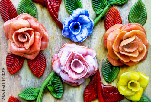 Famous murano glass. Coloured glass flowers on wooden background. Shop in Murano, Venice, Italy.