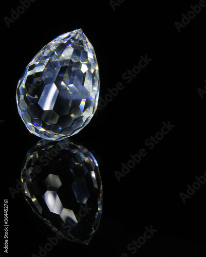 Large faceted crystal on a black reflective surface