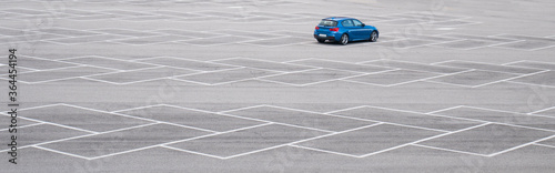 Blue car in an empty parking lot. Horizontal banner with copy space. family sedan without brand. photo