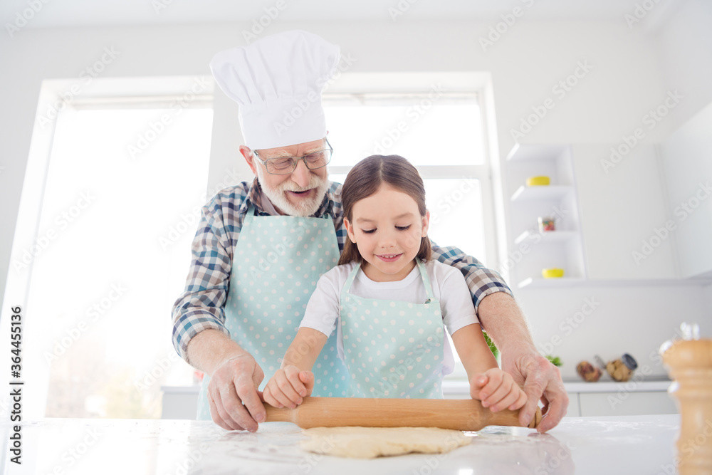 Photo of little girl granddaughter help aged grandpa forming dough rolling pin baking cookies together best friends leisure activity weekend home kitchen indoors