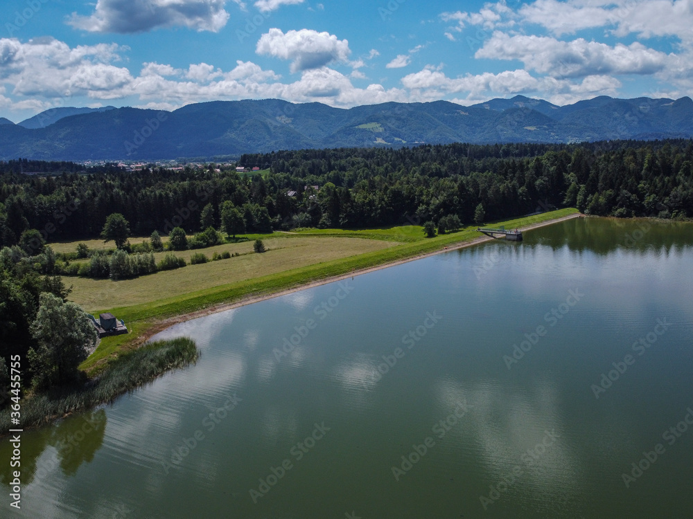 Panorama of Zovnesko jezero or Zovnek lake in Slovenia, on a hot summer day. Visible man made dam in the background used for irrigation.