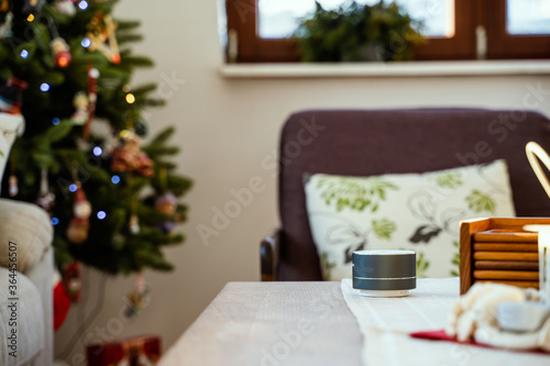 Smartvoice  ai speaker with christmas tree in background. Smart home concept during Christmas holiday winter time