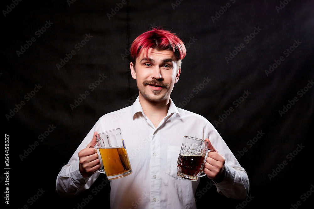 Young handsome guy with red hair in white shirt drinking beer. Funny man with emotions on the face and beer mug in hand and black background. Alcoholic is happy with alcohol Young handsome guy with red hair in white shirt drinking beer. Funny man with emotions on the face and beer mug in hand and black background. Alcoholic is happy with alcohol
