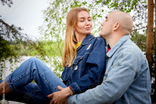 Kirov, Russia - June 22, 2020: European couple of blonde woman and bald man walking at park, enjoying and being happy together. Love and tenderness concept. Lovers on date outdoors at nature. © keleny