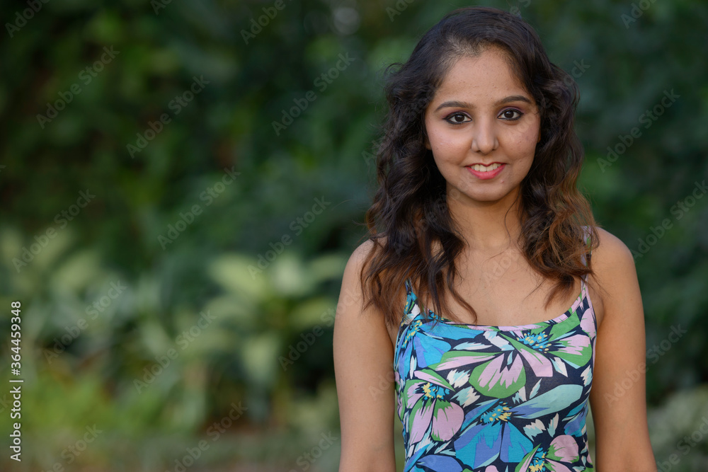 Happy young beautiful Indian woman smiling at the park Happy young beautiful Indian woman smiling at the park