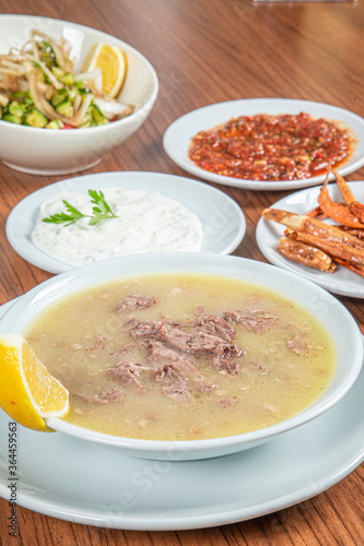 Turkish Traditional Soup with bread on white rustic wooden background, kelle, paca corbasi.