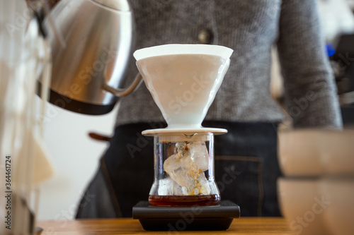 Woman barista preparing a V60 filter specialty coffee in a cafe photo