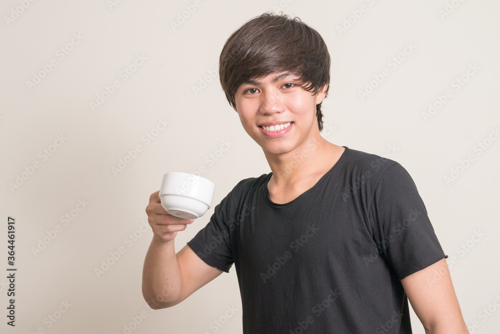 Portrait of happy young Filipino man drinking coffee Portrait of happy young Filipino man drinking coffee