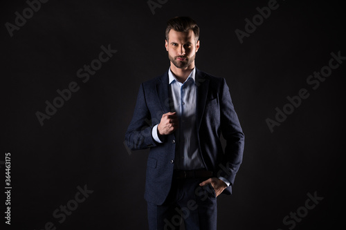 Portrait of his he nice attractive perfect imposing rich wealthy guy corporate partner mr mister wearing expensive good suit apparel isolated on dark black color background © deagreez