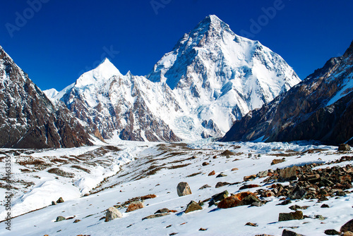 Snow peaks of mountains with Chogori K2 with blue sky. Winter tourism in Karakorum, Pakistan. Snow valley on horisontal landscape.