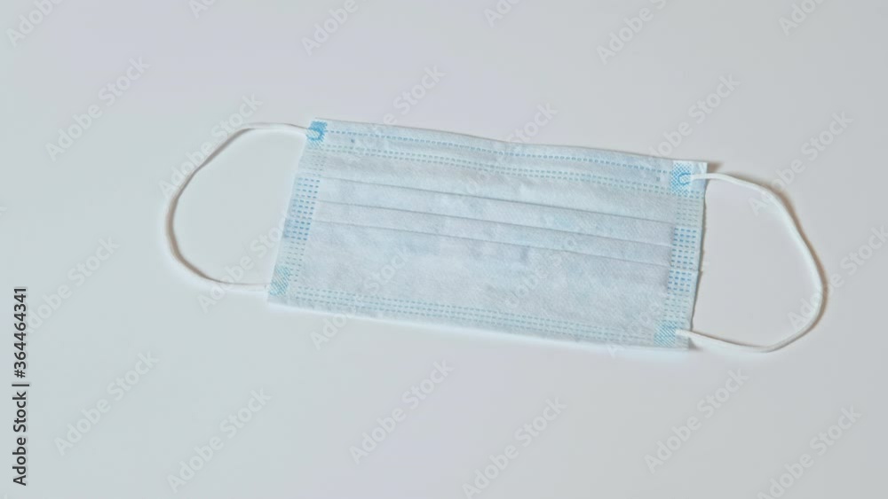 Hygiene equipment. COVID-19 prevention. Doctor hand in pink protective glove giving face mask isolated on white. Hygiene equipment. COVID-19 prevention. Doctor hand in pink protective glove giving face mask isolated on white.
