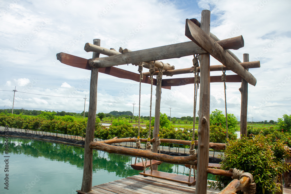 Green water views, beautiful flowers surrounded, and blur wooden swings, perfect for relaxing during holidays. Green water views, beautiful flowers surrounded, and blur wooden swings, perfect for relaxing during holidays.