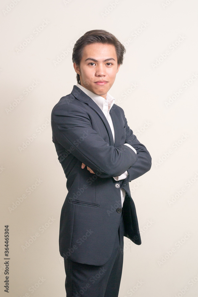 Profile view of young Filipino businessman in suit with arms crossed Profile view of young Filipino businessman in suit with arms crossed