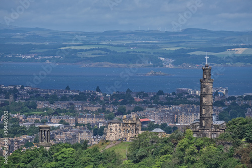 Aerial view of the Calton Hill in Edinburgh, with famous monuments such as the Nelson Monument, the Dugald Stewart and the observatory and the ocean in the background photo