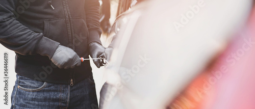 Quadro em tela Close up car thief hand holding screwdriver tamper yank and glove black stealing automobile trying door handle to see if vehicle is unlocked  trying to break into inside