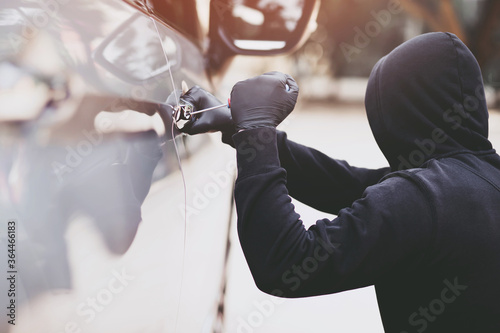 Foto Close up car thief hand holding screwdriver tamper yank and glove black stealing automobile trying door handle to see if vehicle is unlocked  trying to break into inside