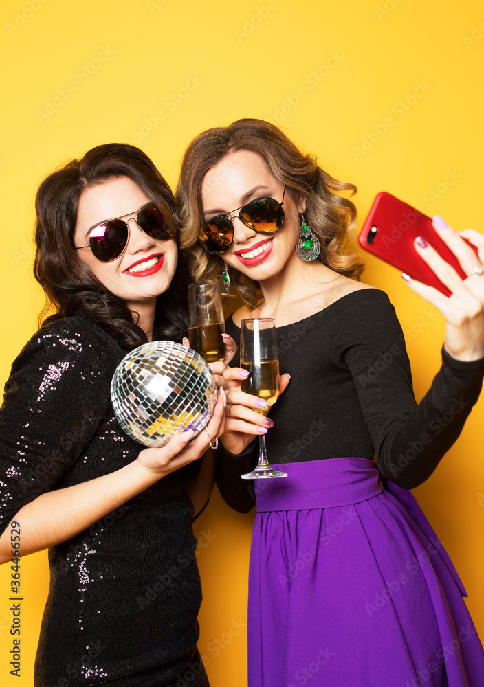 two girls with glass of wine and disco balls, make selfie, happy and smile.