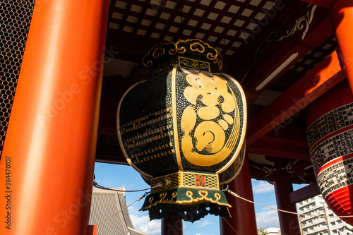 Large traditional Chochin lantern with oriental ornaments hanging in Senso-ji Buddhist Temple in Tokyo.