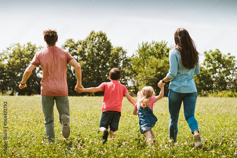 Carefree young family running through a meadow Carefree young family running through a meadow