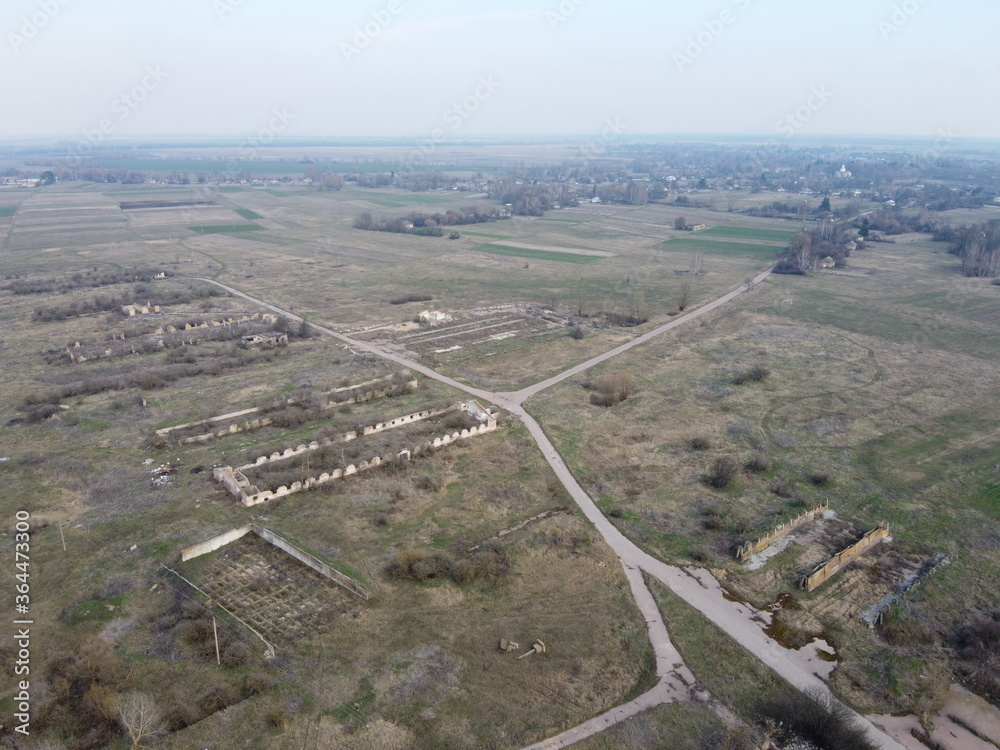 Destroyed agricultural buildings, aerial view. Abandoned livestock farm.