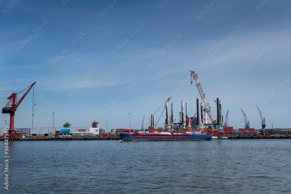Huge cranes and ships anchored at harbor. International commercial port