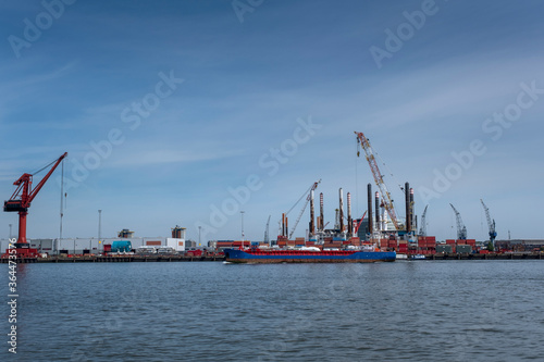 Huge cranes and ships anchored at harbor. International commercial port