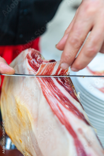 Un jamón recién abierto por un cortador de jamones con su cuchillo jamonero photo