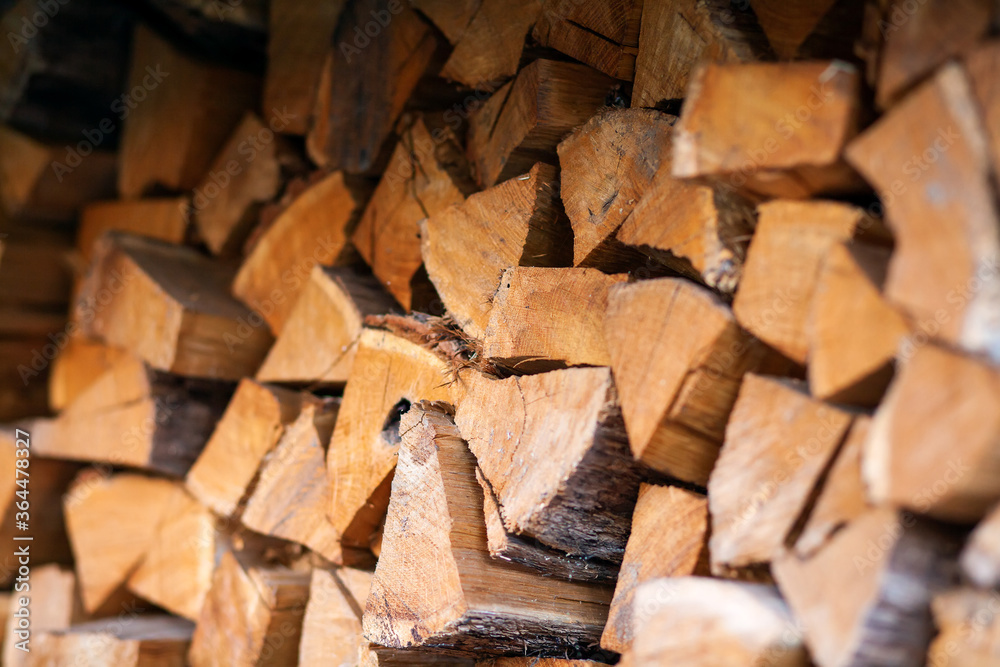 Firewood in logs, large and small chopped branches. Chipped firewood is in storage. Finished firewood for the bath and fireplace. Background of firewood. Firewood in logs, large and small chopped branches. Chipped firewood is in storage. Finished firewood for the bath and fireplace. Background of firewood.