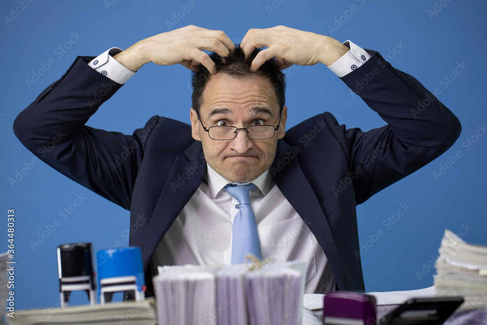 Φωτογραφία Middle-aged businessman amazed and opened his eyes wide and tears his head hair