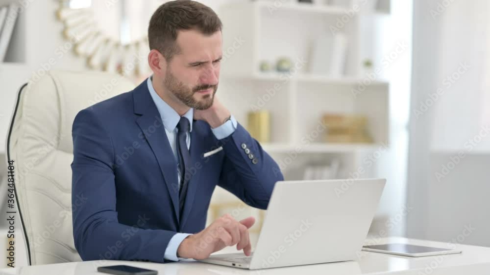 Businessman with Laptop having Neck Pain in Office Businessman with Laptop having Neck Pain in Office