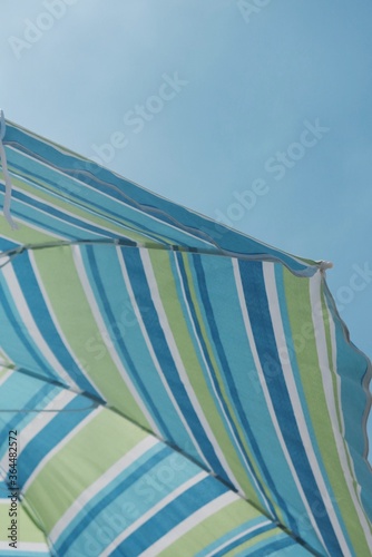 parasol bleu vert et blanc sous un ciel bleu
