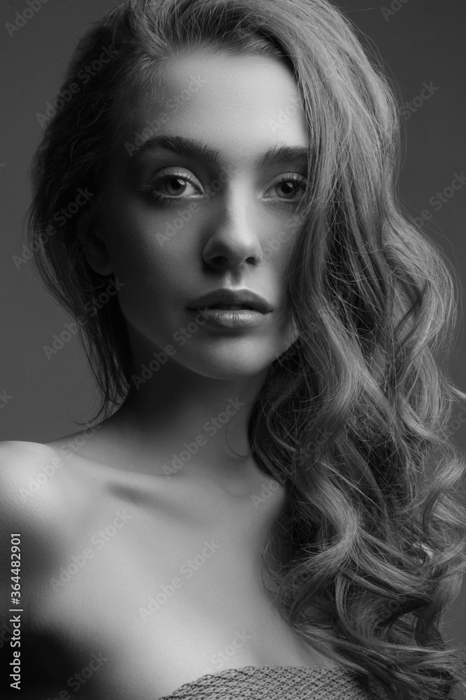 Young woman with perfect skin. Black and white studio portrait. Girl with beautiful hair. Dark background Young woman with perfect skin. Black and white studio portrait. Girl with beautiful hair. Dark background