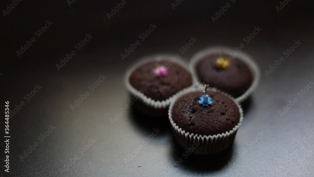 Blurry view of little brownie cakes and birthday candles. Blurry view of little brownie cakes and birthday candles.