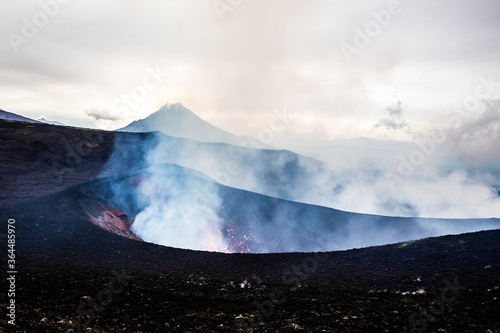 Crater of erupting volcano on the overcast weather, volcanic landscape