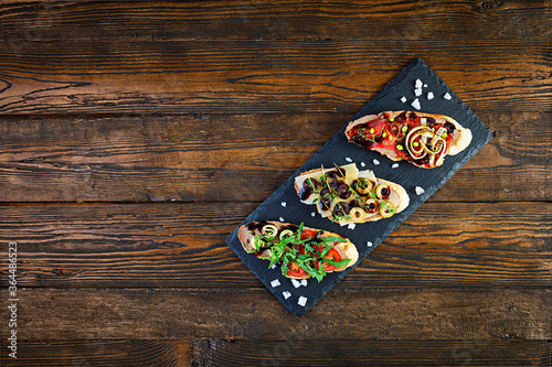 Bruschetta with chicken liver paste. Delicious bruschettas with various fillings. Different bruschetta ob wooden background