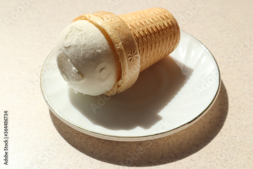 A plate of ice cream in a waffle Cup on the kitchen table, close-up, top view