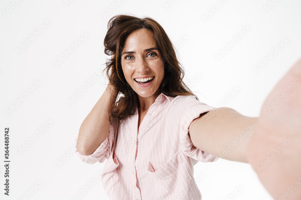 Image of happy nice woman smiling while taking selfie photo Image of happy nice woman smiling while taking selfie photo