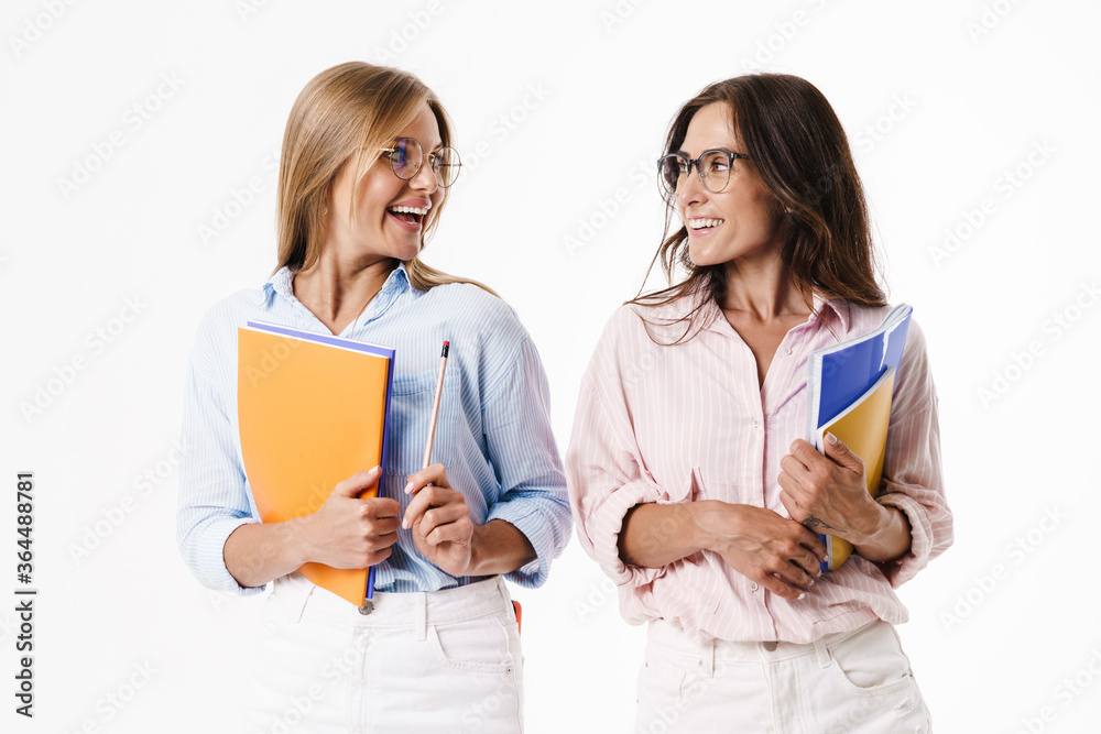 Image of happy women smiling while posing with exercise books Image of happy women smiling while posing with exercise books