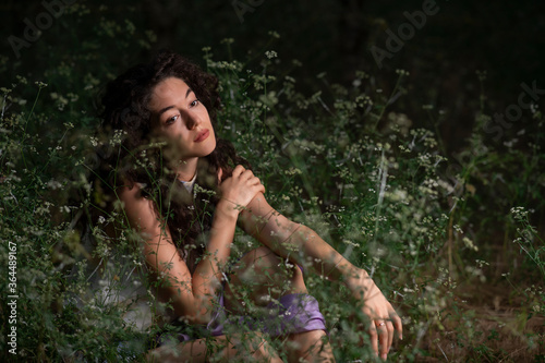 Fototapeta Naklejka Na Ścianę i Meble -  Beautiful young woman posing in a dark forest 