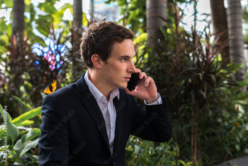 Portrait of young handsome businessman talking on the phone at the park Portrait of young handsome businessman talking on the phone at the park