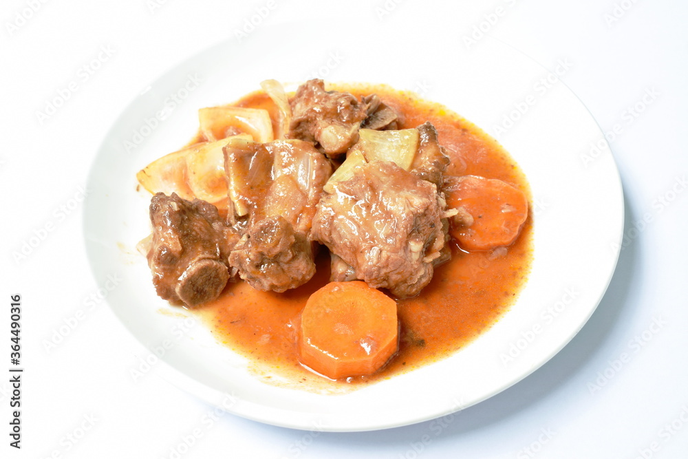 fried pork bone with slice carrot and onion with swet and sour sauce on plate fried pork bone with slice carrot and onion with swet and sour sauce on plate