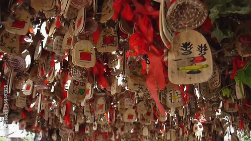 wooden notes with Chinese characters and red ribbons hanging like decorations on the street, Lijian, China photo