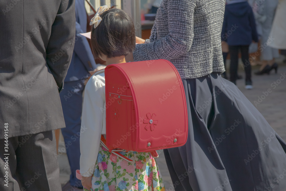 入学式に向かう赤いランドセルをしょった新一年生の女の子とその両親 Stock Photo Adobe Stock