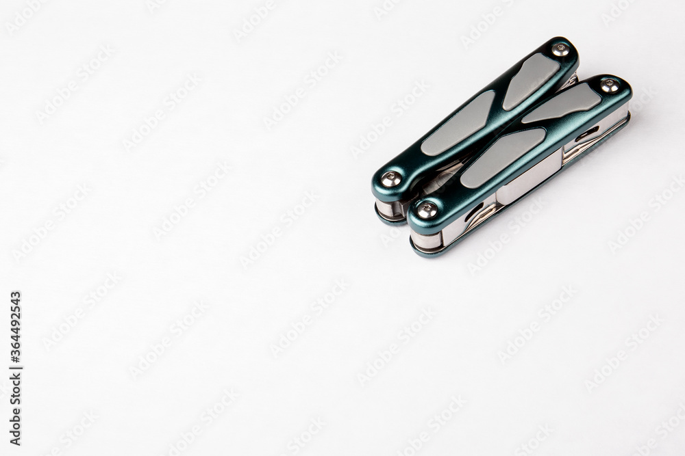 Compact multitool on white background. Top view. Tools for cutting, sawing, screwing, filing, compressing, bottle opening Compact multitool on white background. Top view. Tools for cutting, sawing, screwing, filing, compressing, bottle opening